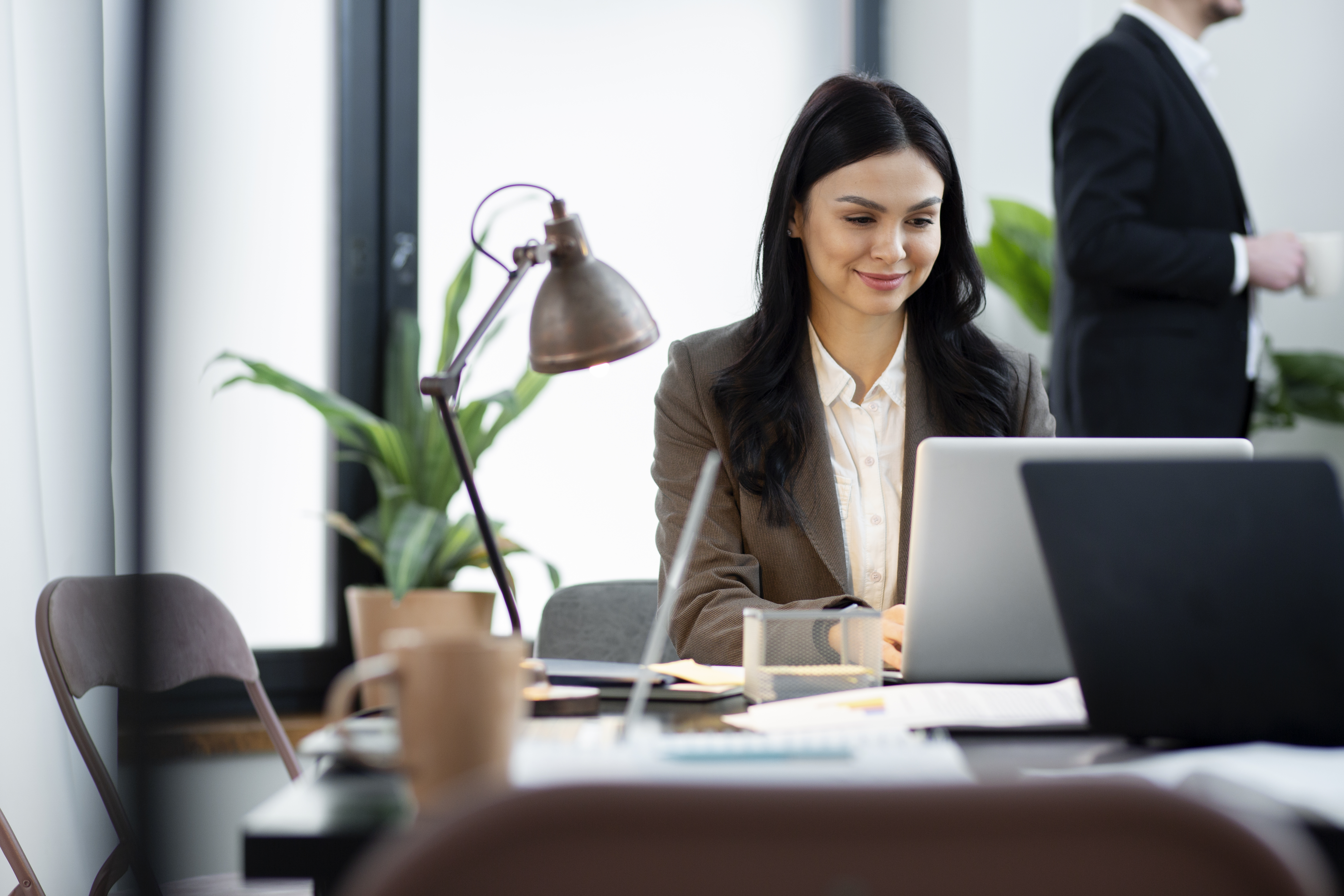 Finance & Controlling Header Eine Frau sitzt am Schreibtisch und arbeitet am Laptop