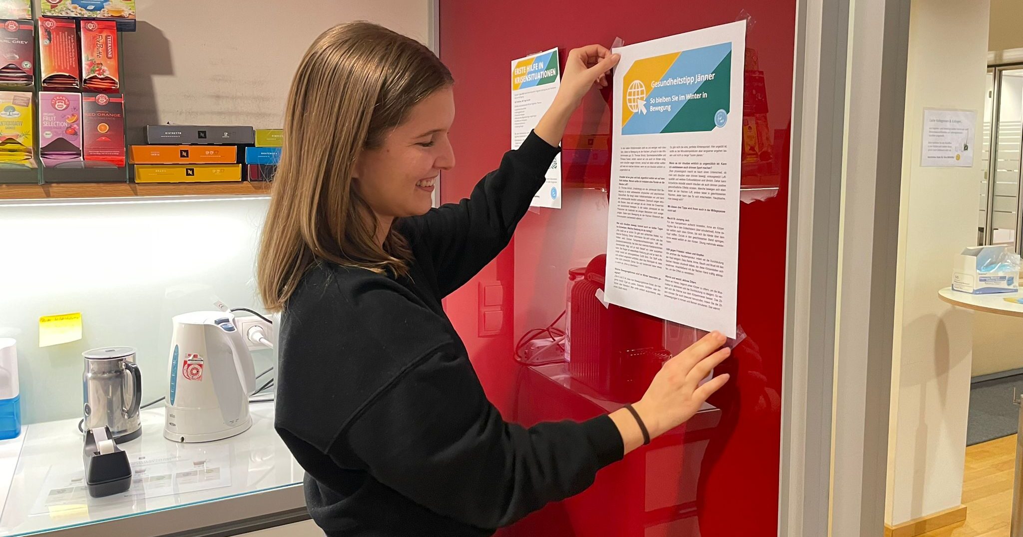 Kathi klebt unser Gesundheitstipps für alle sichtbar in die Küche an die Wand.