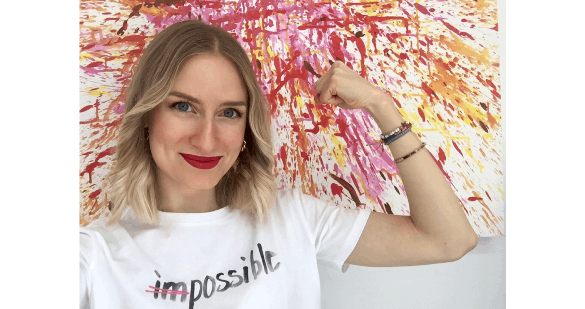 Marie trägt ein T-Shirt mit der Aufschrift "Impossible", das "Im" ist dabei durchgestrichen und spannt ihren Arm an.